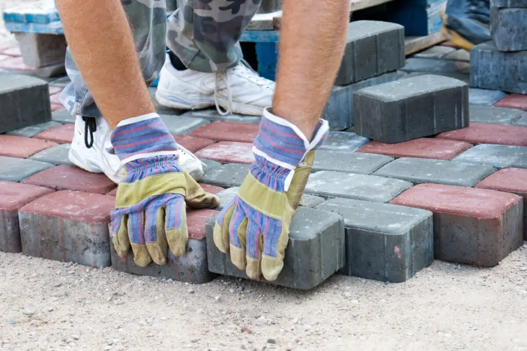 a worker made a sidewalk from bricks